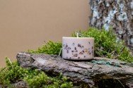 9. Top view of TL Candles hand-made soy wax candle with amber pieces, alongside branded packaging