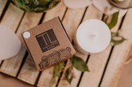 7. TL Candles packaging and soy wax candle on wooden surface, emphasizing hand-made quality and pine scent