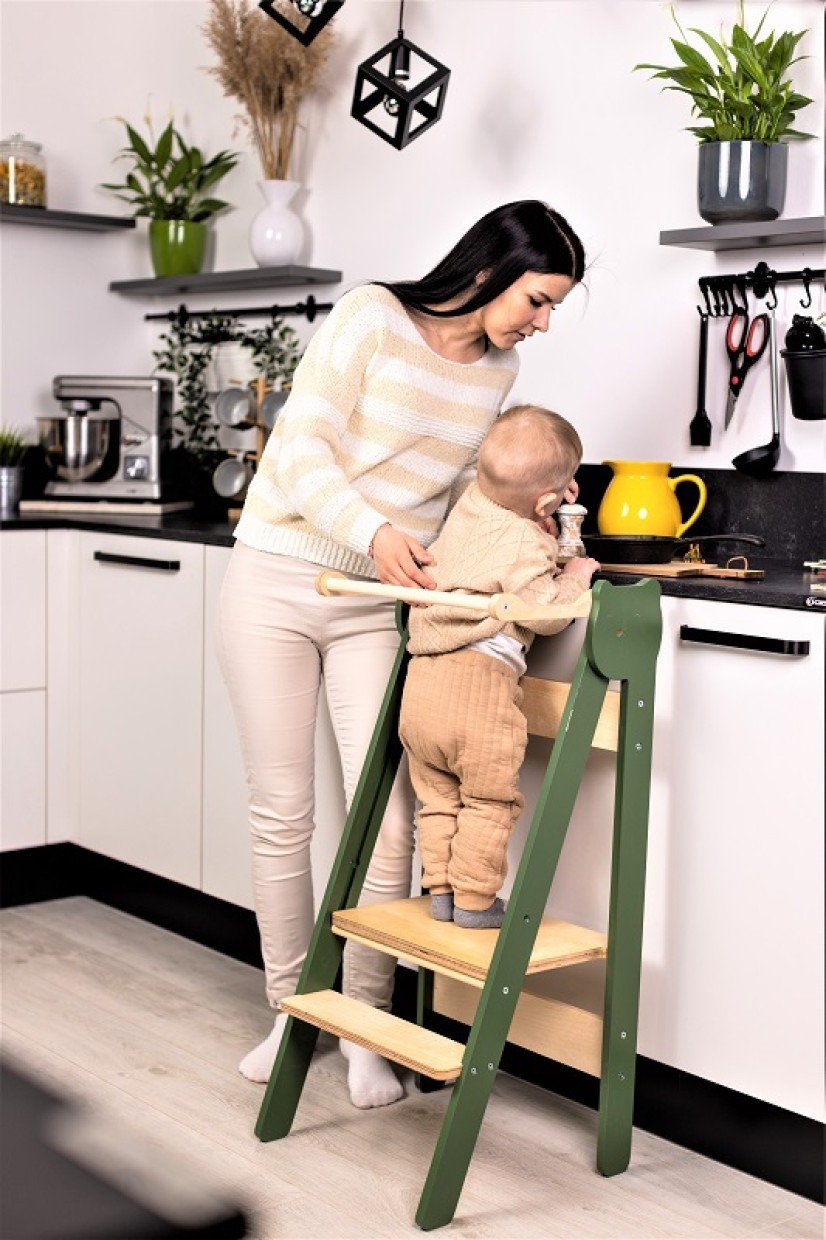 12. Woman and child using green step stool in kitchen