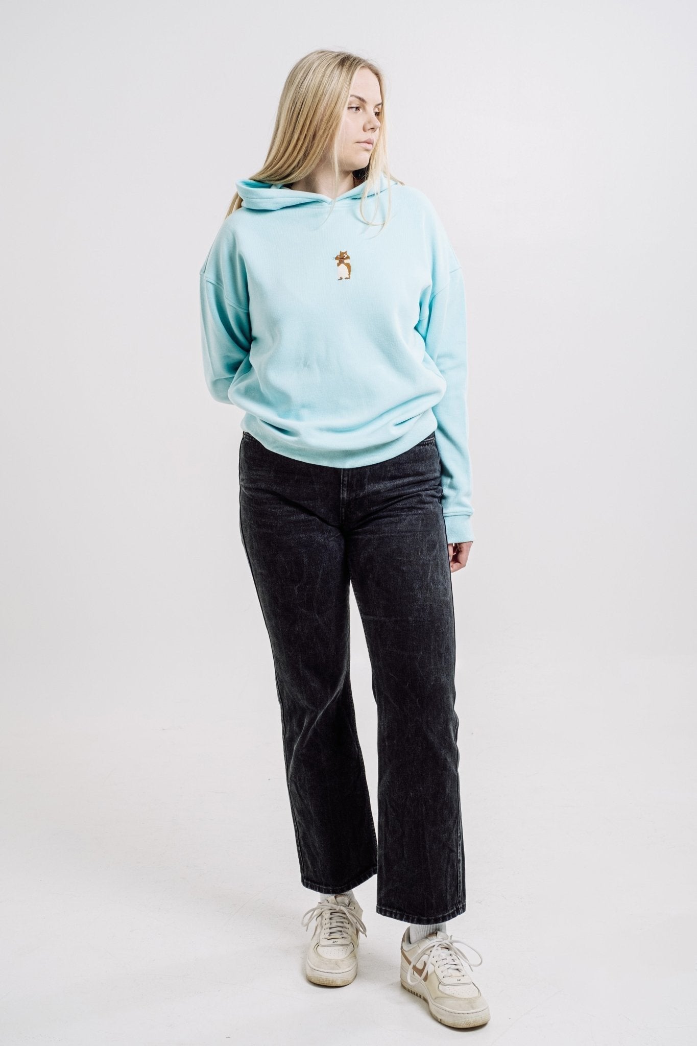 2. Woman modeling Sossu Squirrel Hoodie in mint, highlighting unisex design and comfort in studio
