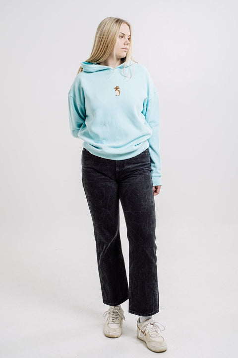 2. Woman modeling Sossu Squirrel Hoodie in mint, highlighting unisex design and comfort in studio