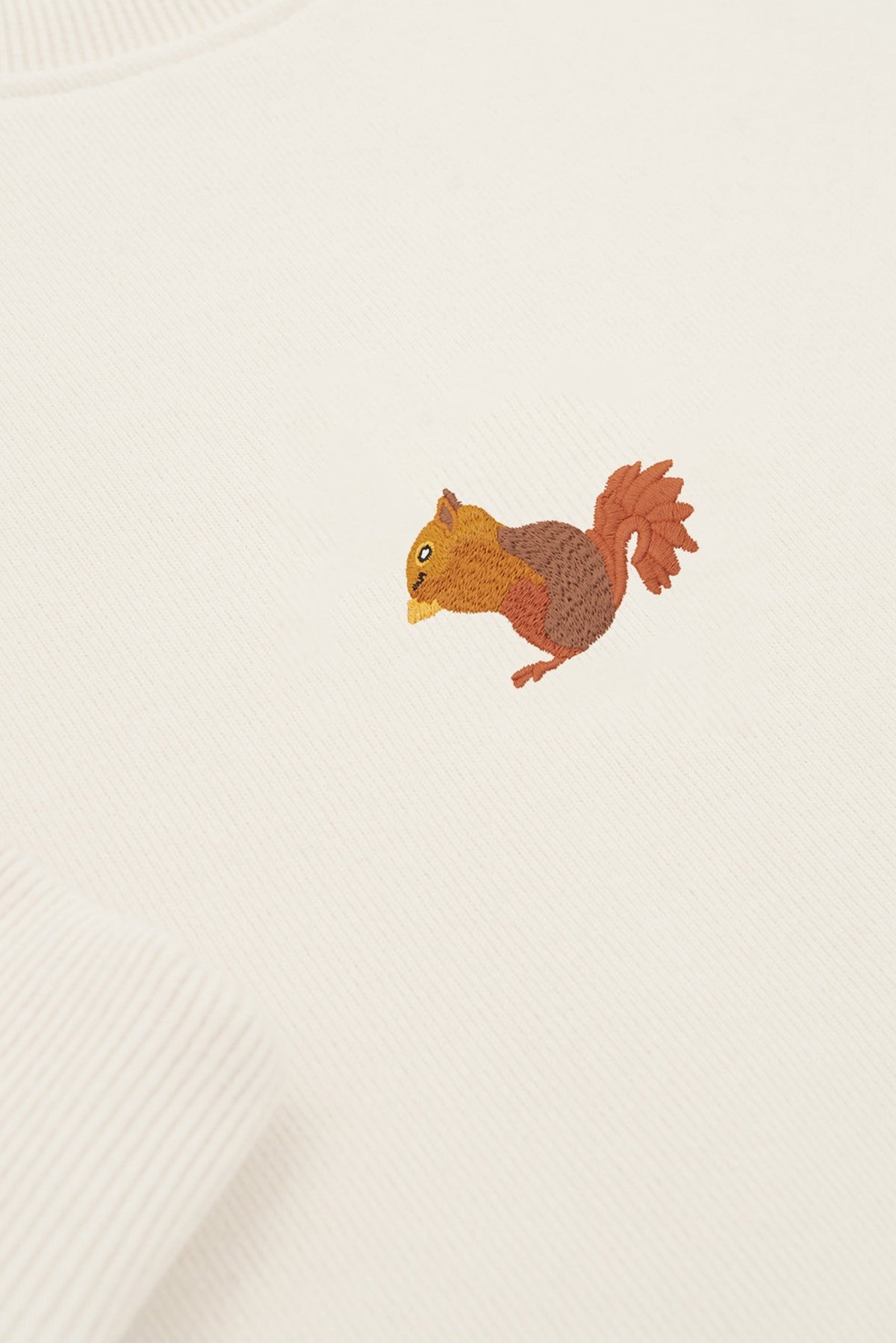 5. Close-up of cream Sossu Squirrel Sweatshirt showing embroidered squirrel design