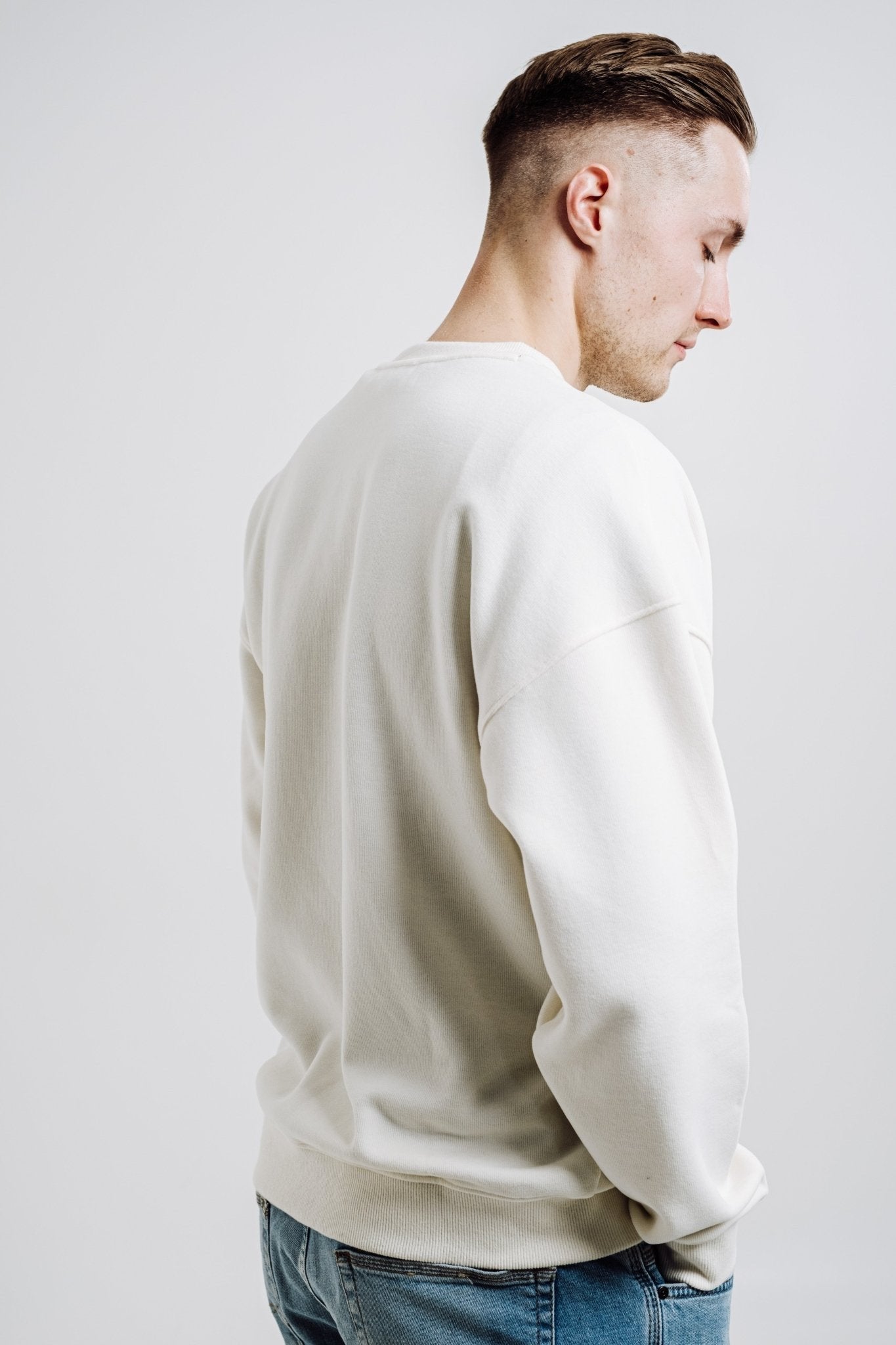 2. Back view of unisex cream Sossu Squirrel Sweatshirt on male model in studio