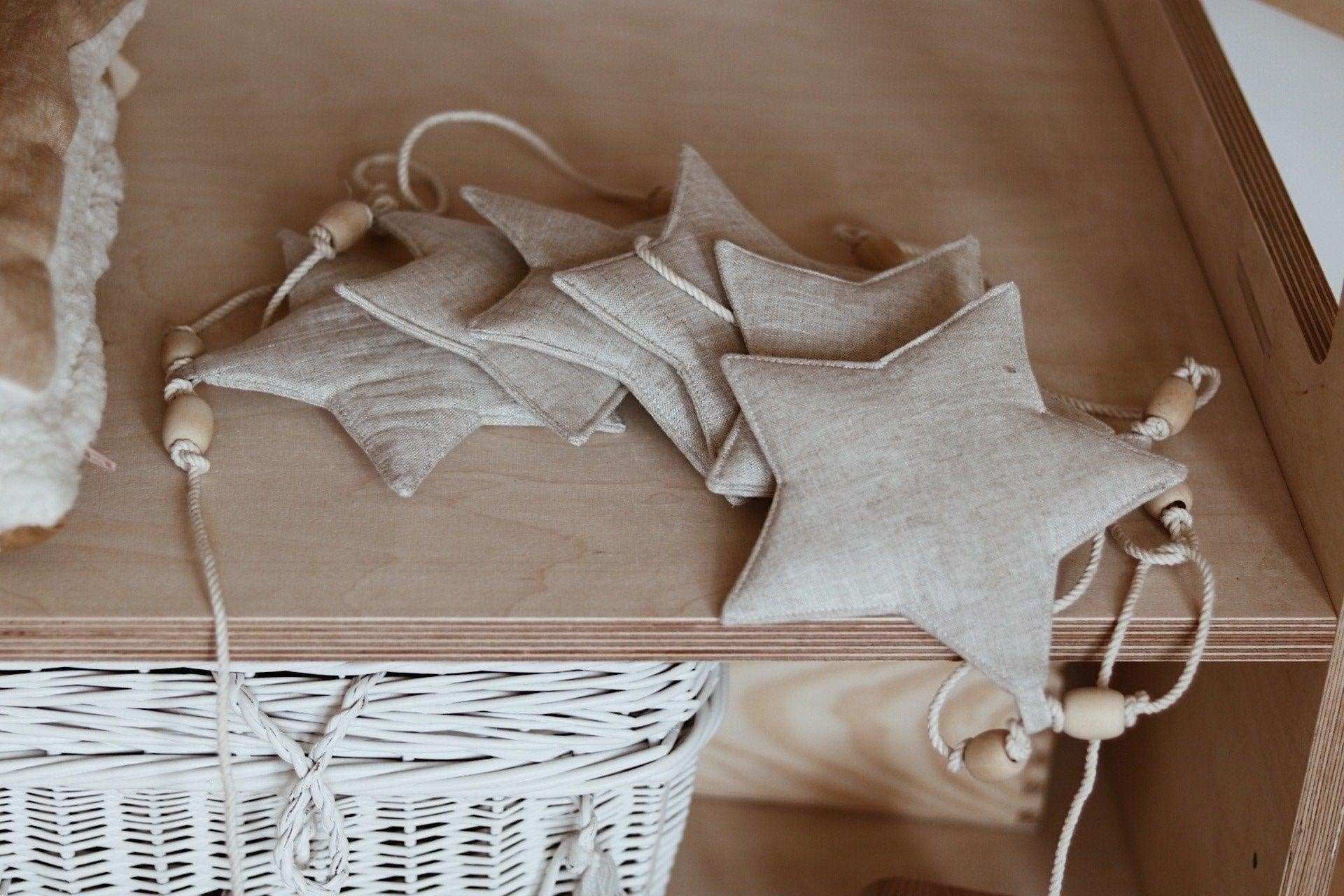 2. Linen star garland with wooden beads on wooden shelf, highlighting rustic charm