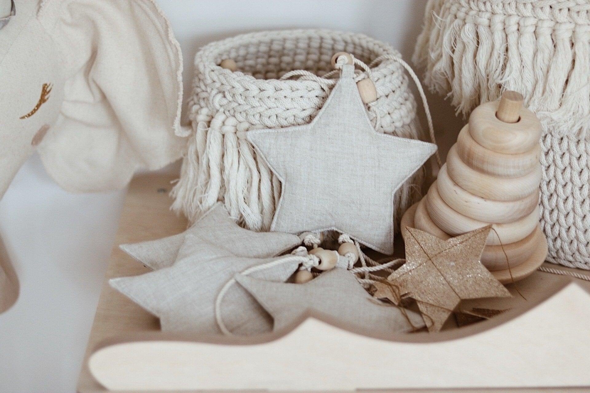 7. Linen star garland with wooden beads among woven baskets and toys, enhancing natural decor