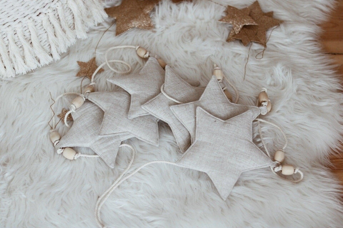 1. Linen star garland with wooden beads on fluffy white rug, showcasing natural decor