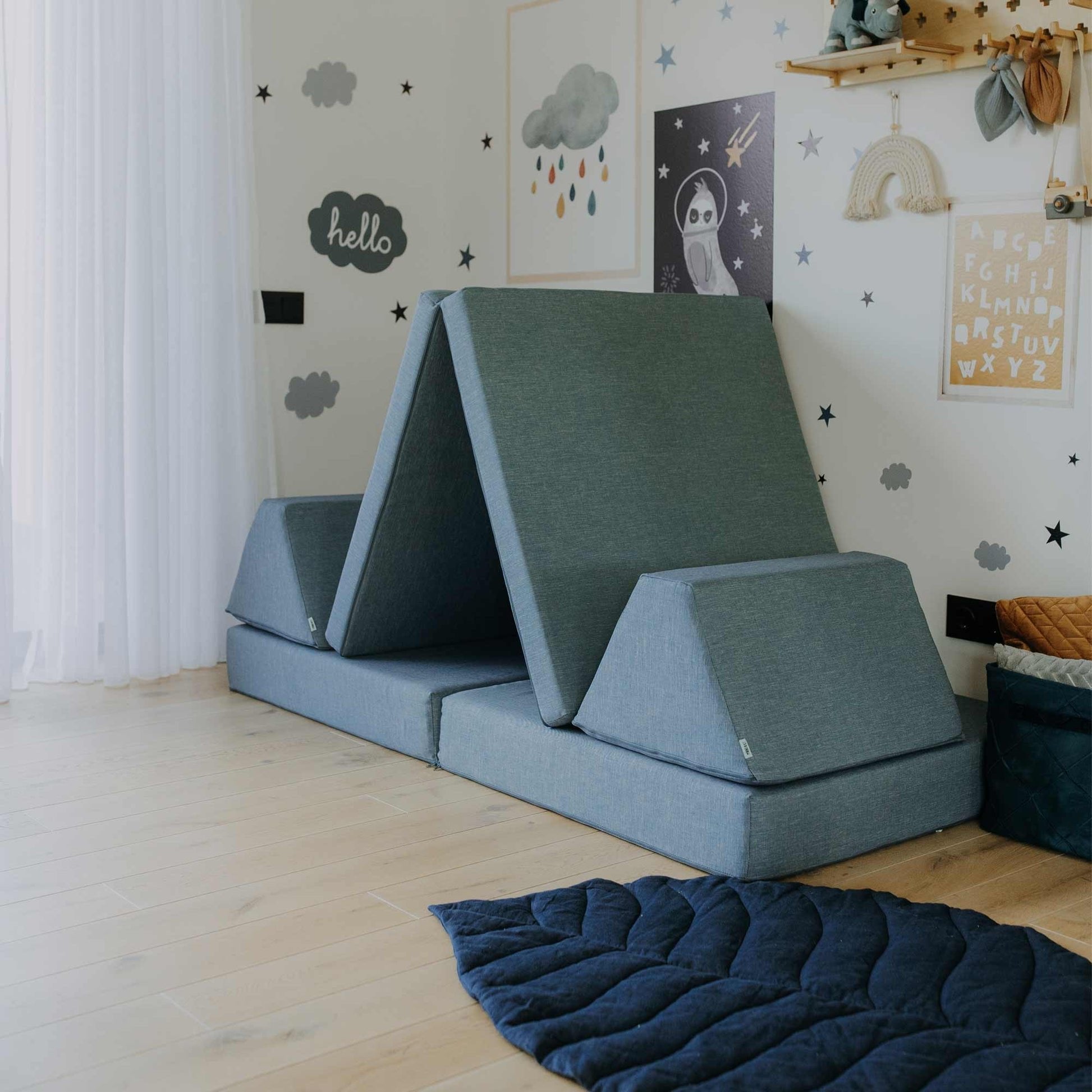 10. Turquoise Monboxy play mattress set arranged as a tent in a star-themed children's room