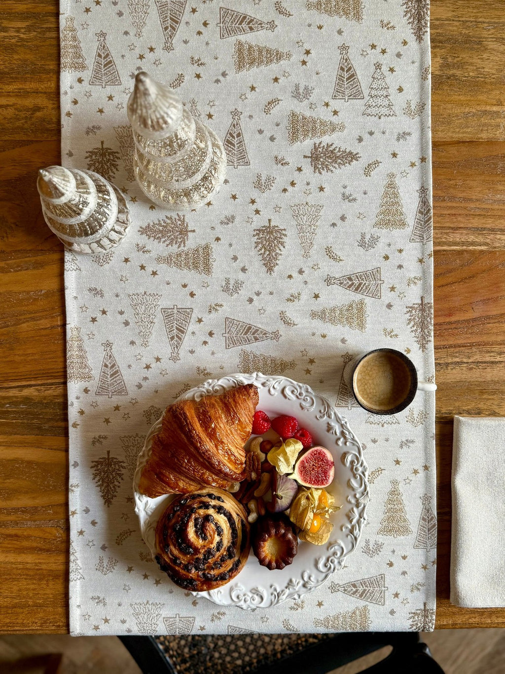 1. Golden Forest table runner with festive motif on wooden table, featuring pastries and coffee, creating a cozy dining setting