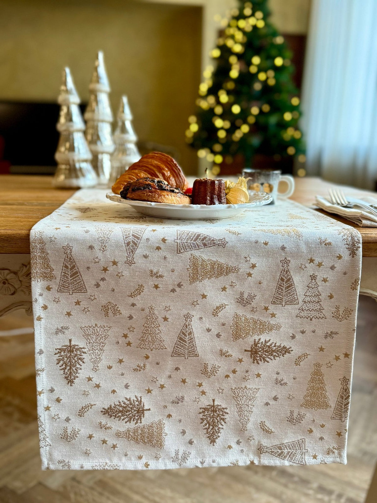 3. Golden Forest table runner on dining table with pastries, coffee, and Christmas tree in background, showcasing holiday decor