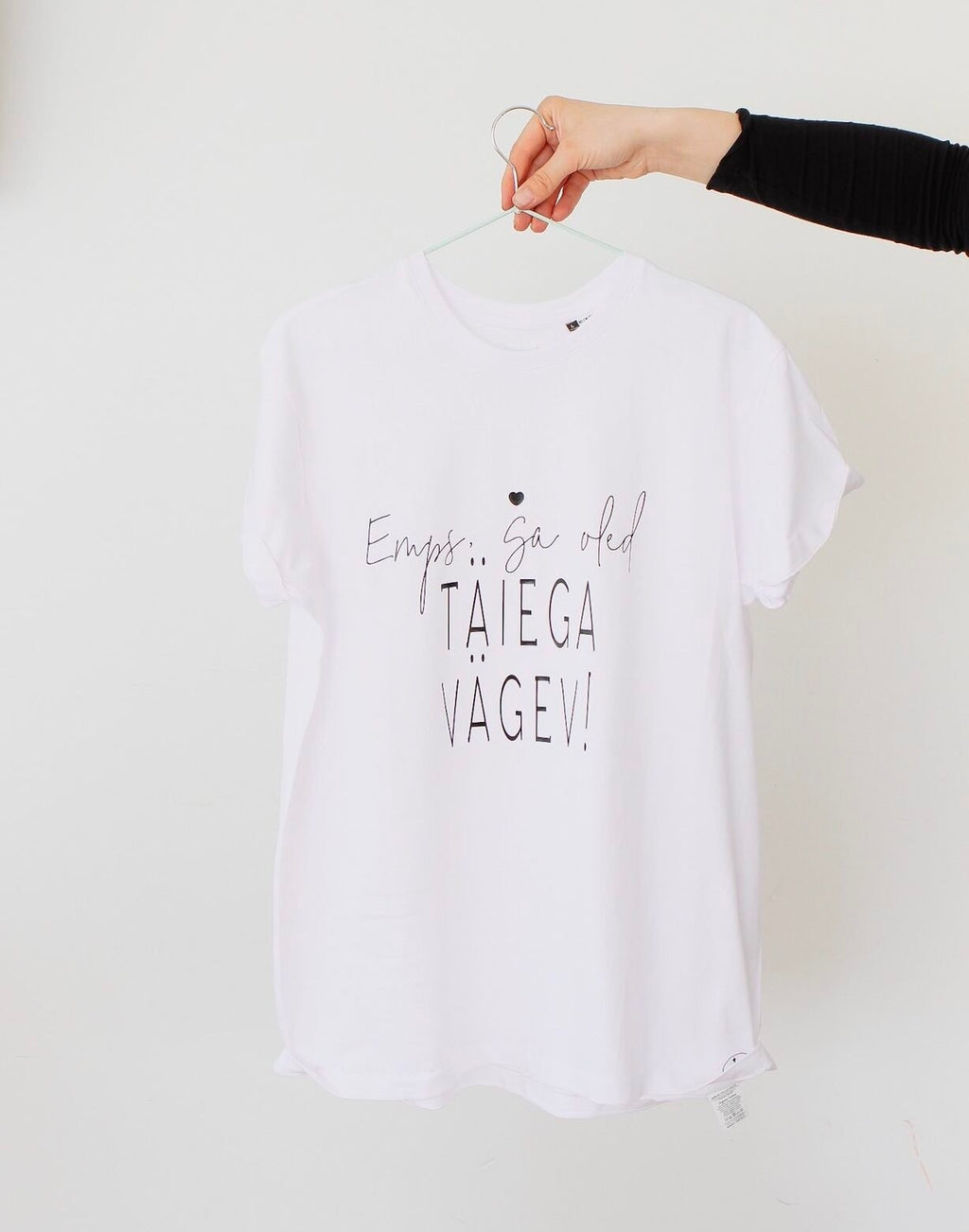 3. Studio shot of Black Giraffe Brand white T-shirt with 'Emps, sa oled täiega vägev' text, displayed on hanger