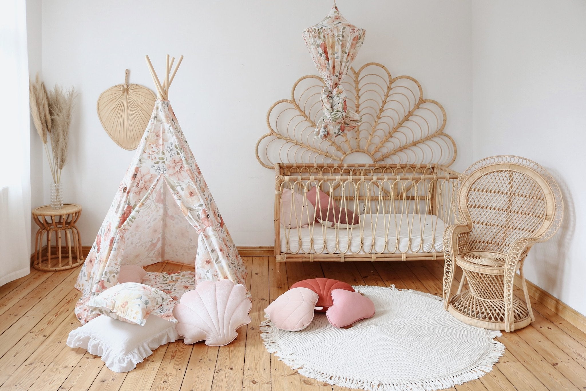 6. Nursery room with floral teepee tent, wicker crib, and pink cushions