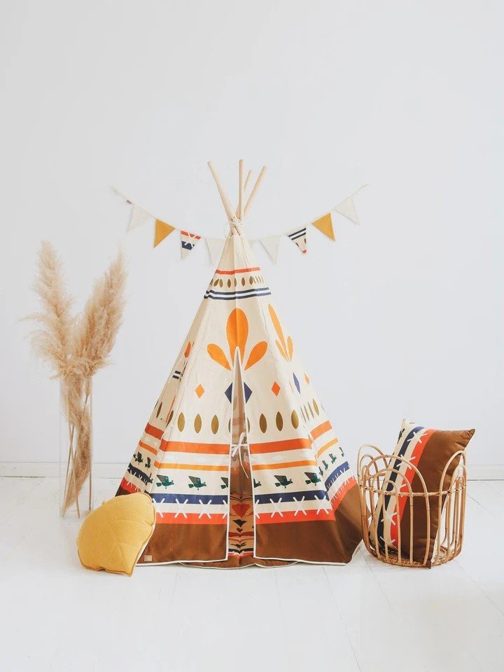 1. Moi Mili teepee tent with geometric prints in a minimalistic room, accompanied by decorative pillows and pampas grass