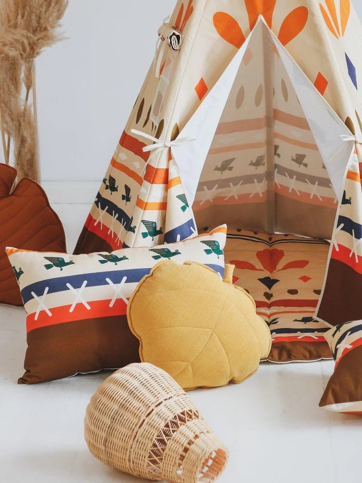 3. Close-up of Moi Mili teepee tent entrance with geometric prints, surrounded by decorative pillows