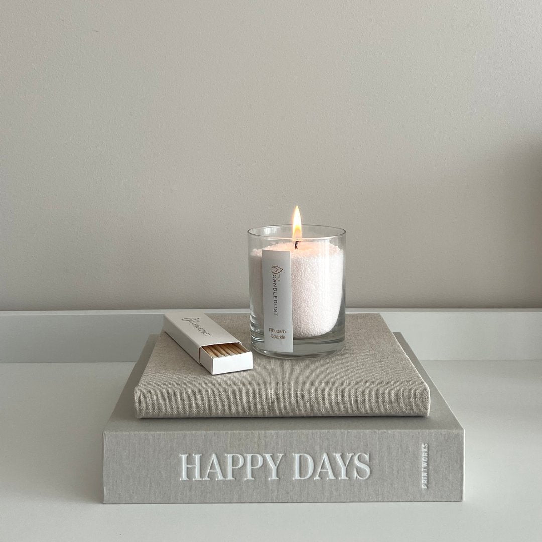 1. Candledust Powdered Candle in Glass - Oasis, lit on a book, creating a cozy ambiance