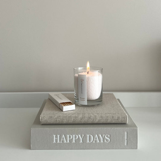 1. Candledust Powdered Candle in Glass - Oasis, lit on a book, creating a cozy ambiance