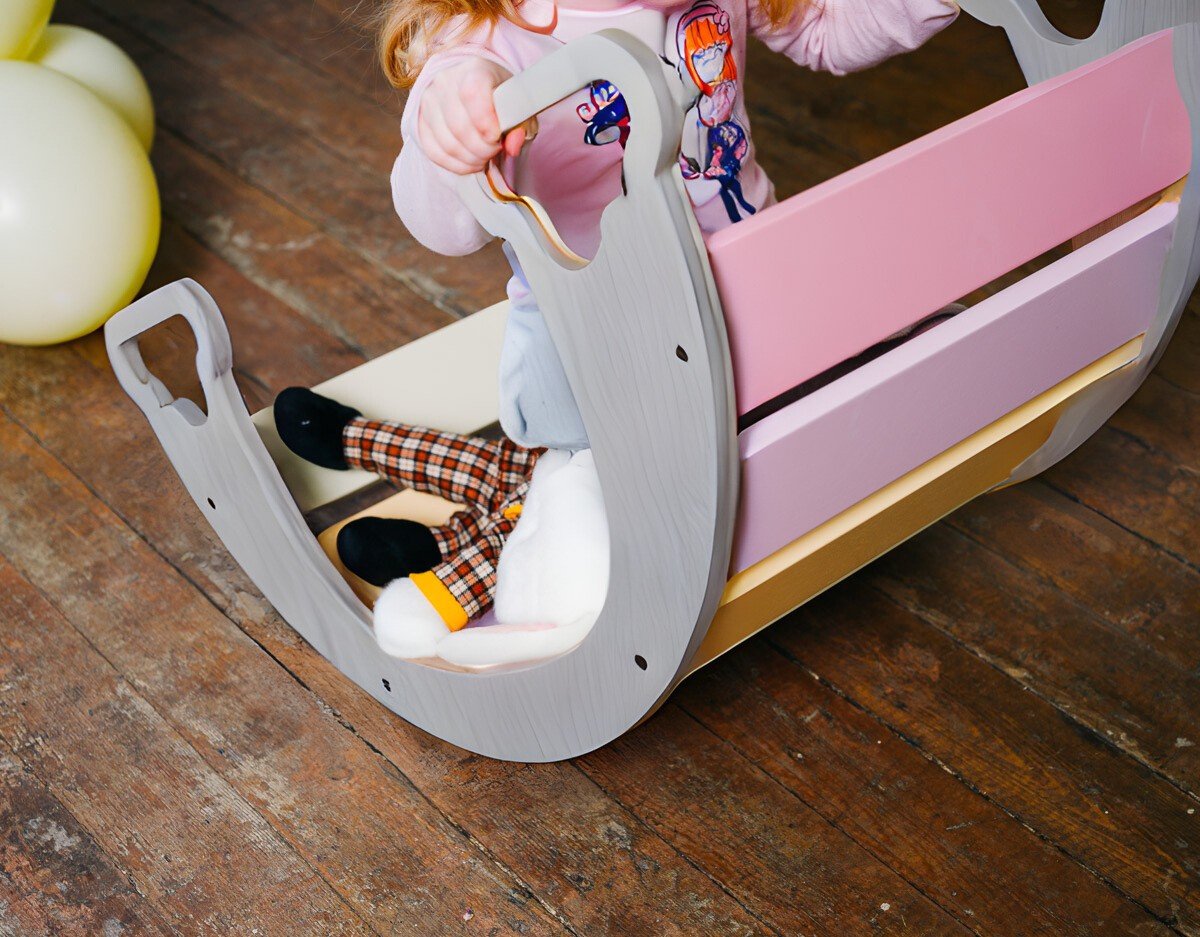 1. Child sitting inside colorful rainbow climber with wooden floor and balloons