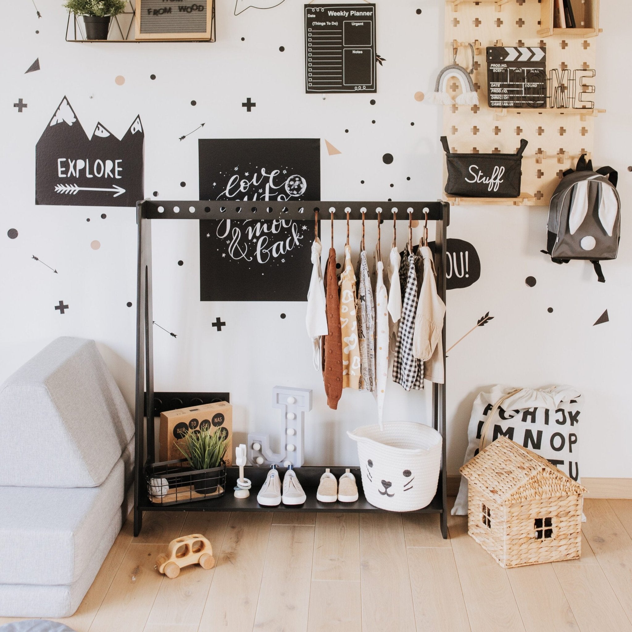 3. Black toddler clothing rack with colorful clothes and toys in a playful, decorated children's room