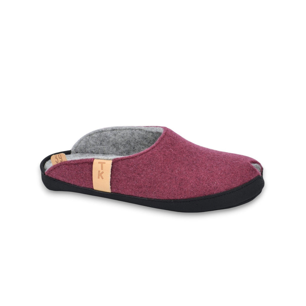 1. Burgundy lambswool felt slippers with black microfibre sole, side view showing arch support and TK logo tag