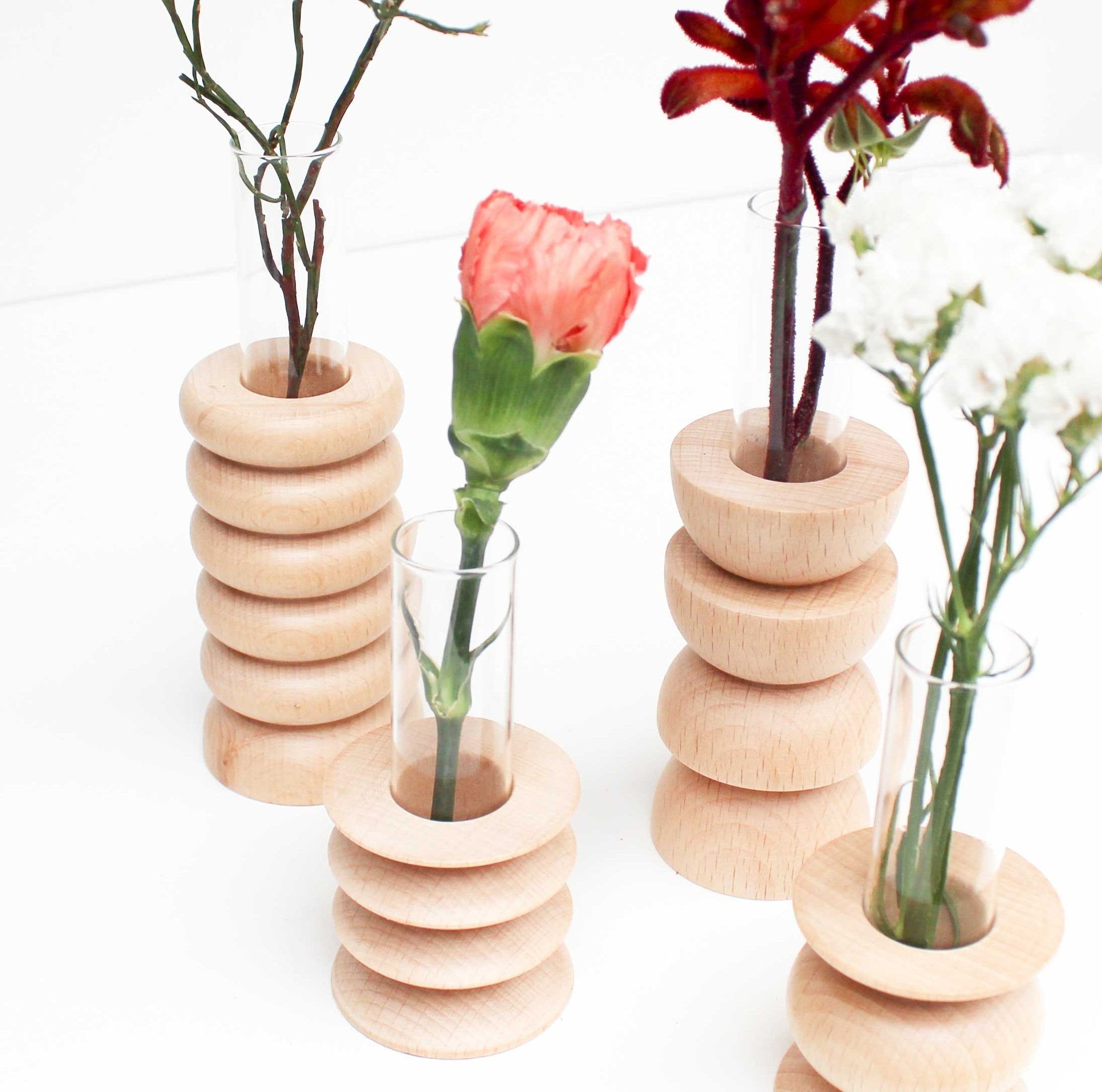 3. Close-up of multiple Totem Wooden Vases by 5mm Paper, highlighting beech wood base and glass tube with various flowers