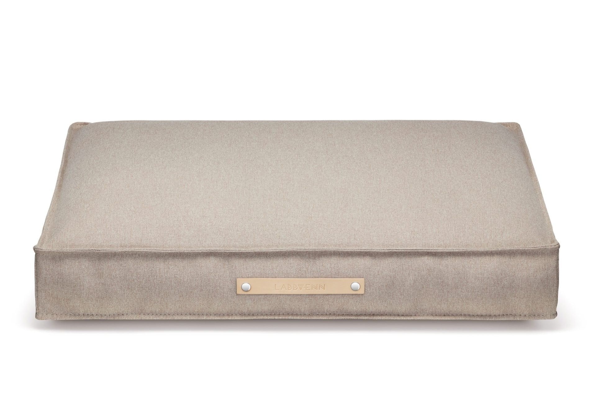 2. Beige Töve cushion by Labbvenn with leather handle and brand logo, shown on a white background