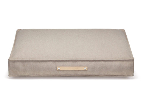 2. Beige Töve cushion by Labbvenn with leather handle and brand logo, shown on a white background