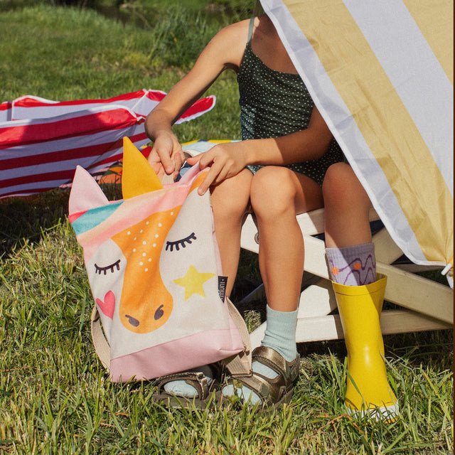 2. Child with MUNI Unicorn backpack in outdoor setting, highlighting vibrant unicorn design and spacious interior