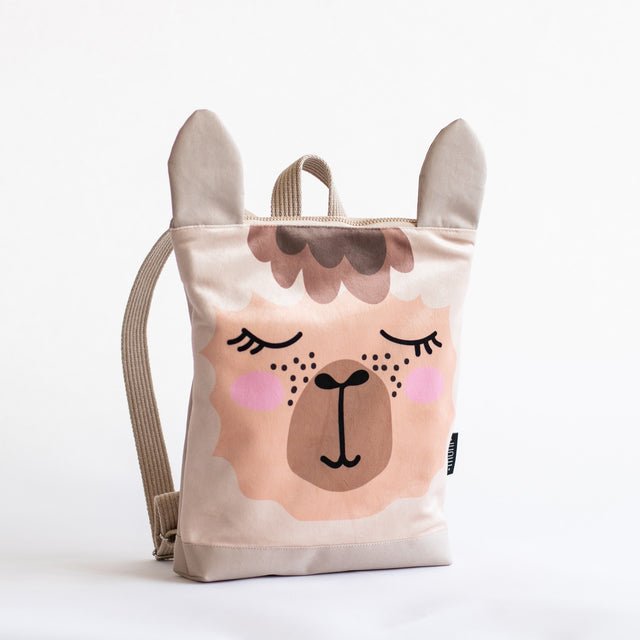 6. Side view of Muni llama backpack in studio, showing adjustable straps and beige polyester bottom