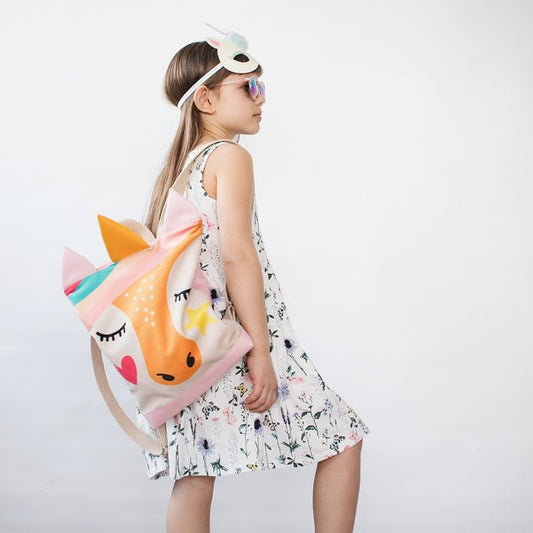 1. Girl wearing MUNI Unicorn backpack in lifestyle setting, showcasing playful design and adjustable straps