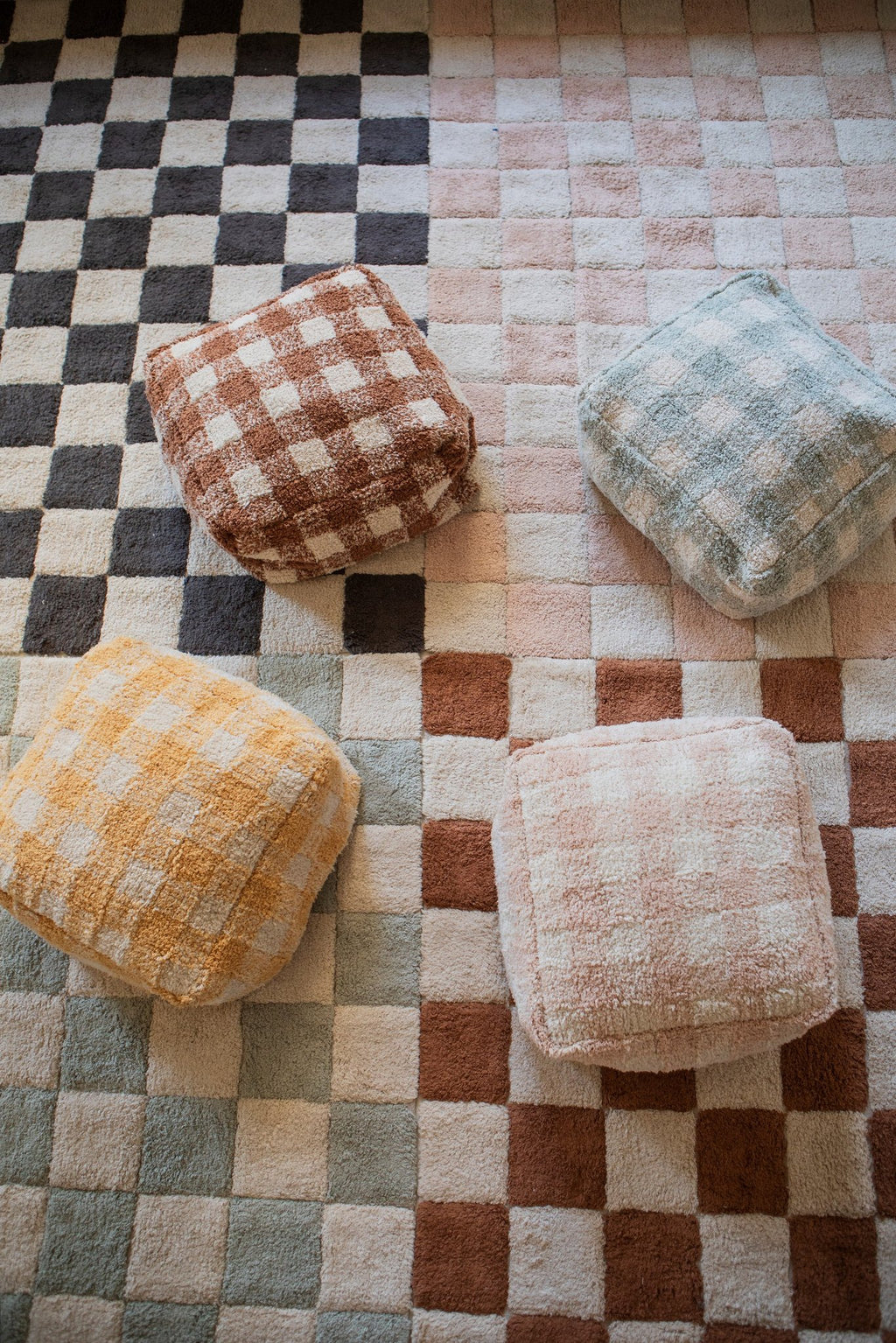 1. Room with Lorena Canals rugs in different colors and matching poufs on a wooden floor