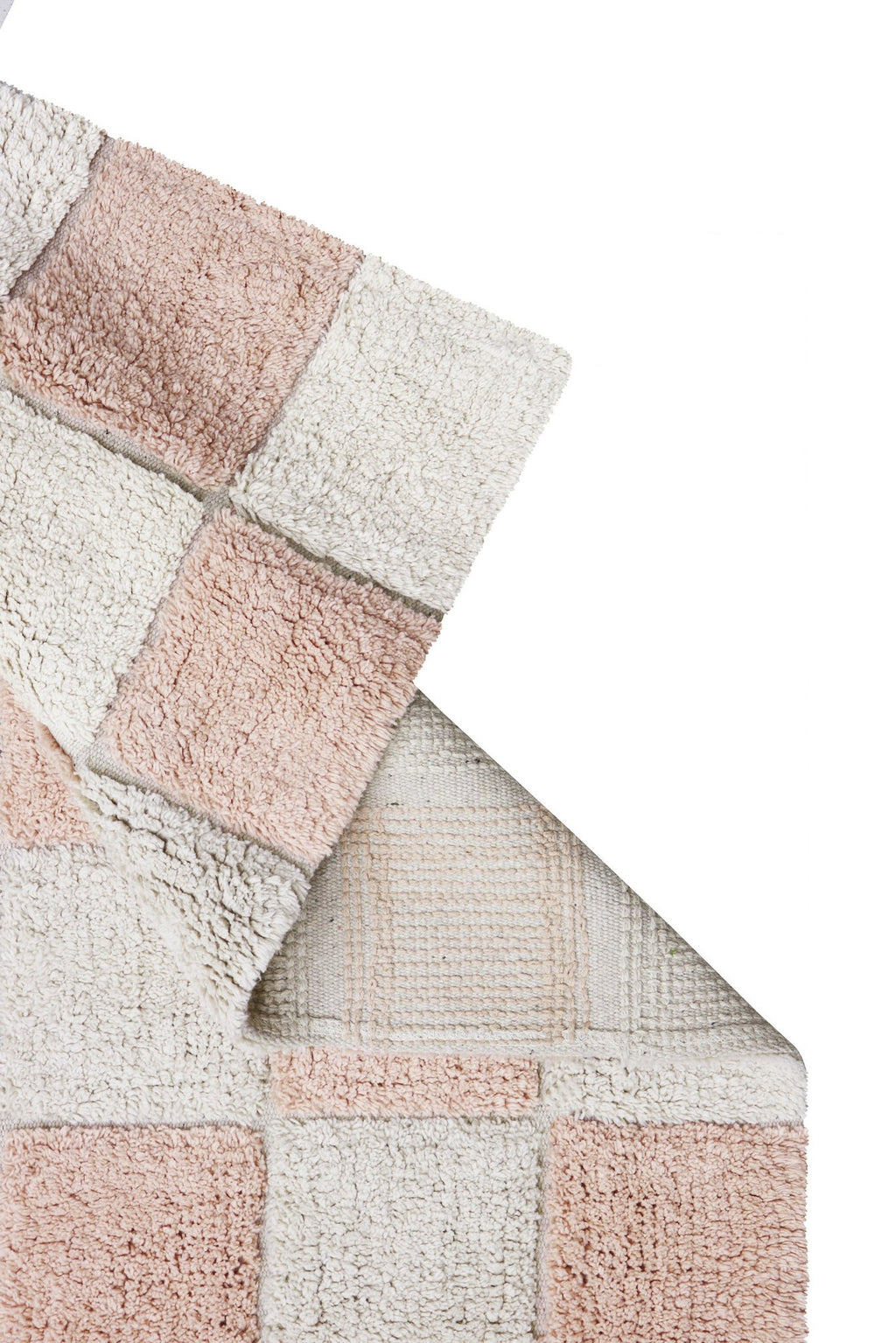 3. Close-up of Lorena Canals rug showing rose and white checkerboard pattern with visible canvas between tiles
