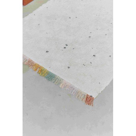 3. Close-up of Lorena Canals Stardust rug highlighting texture, dark dots, and multicolored fringes