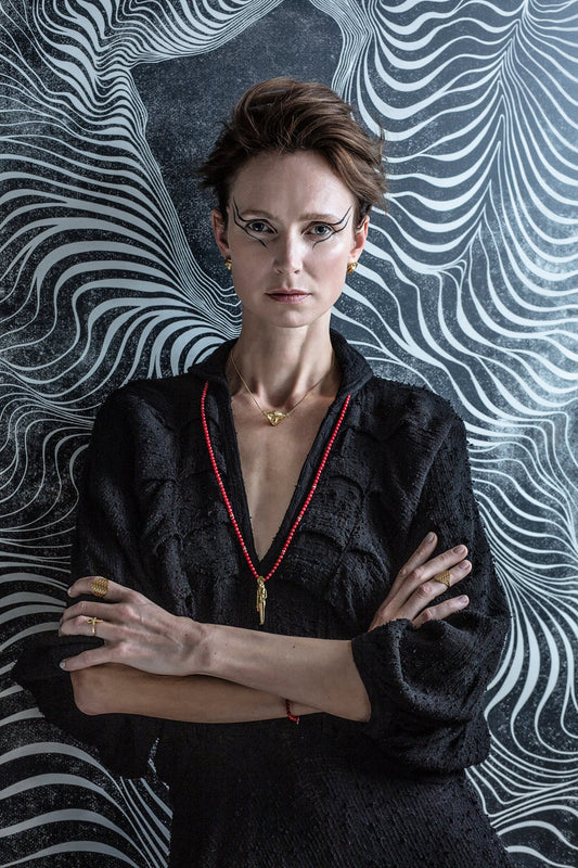 1. Woman wearing Hathor Harmony Choker in gold by New Vintage by Kriss, styled with black outfit in artistic setting