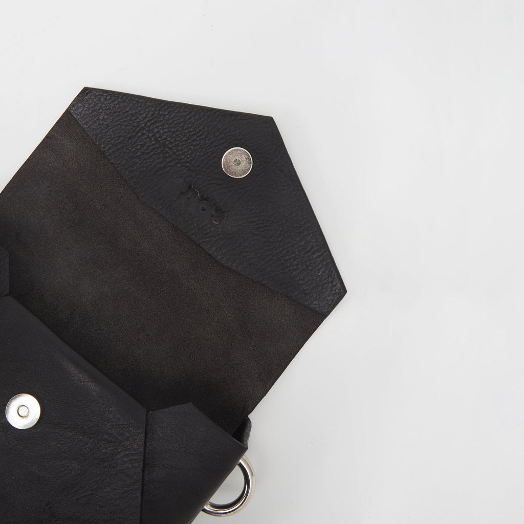 5. Close-up of handmade black leather envelope bag by Daz Studio showing raw leather interior and silver magnet closure