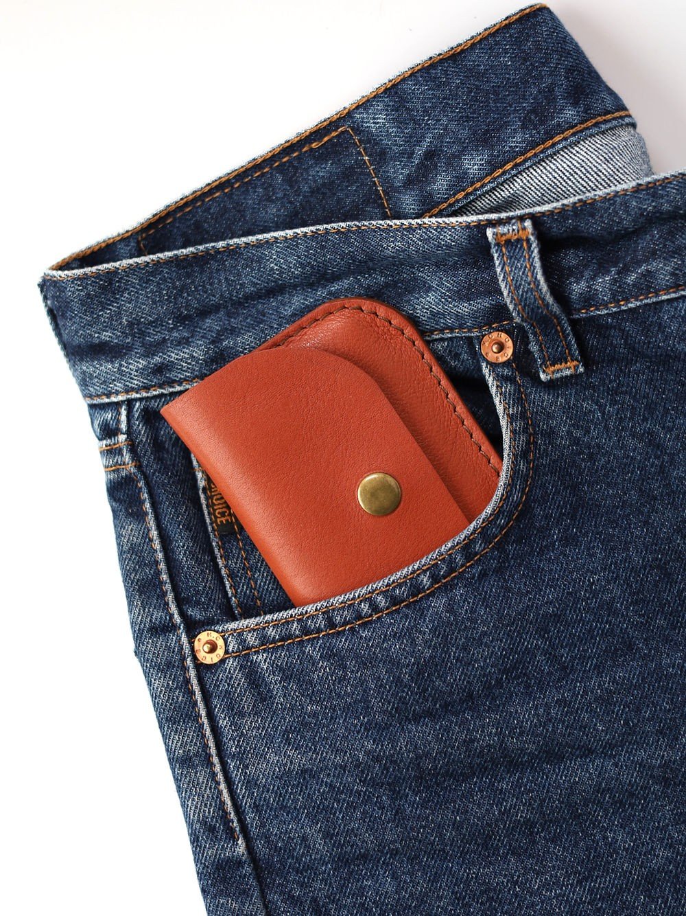 1. Red clay leather wallet by Toks Visoks in blue denim pocket, showcasing compact fit