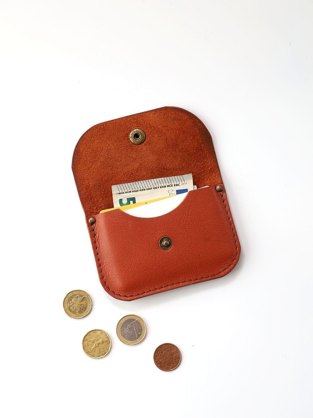 3. Open red clay leather wallet by Toks Visoks with cards and coins on white background