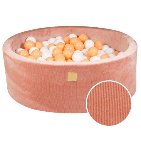 1. Apricot velvet round ball pit filled with white and orange balls, featuring soft hypoallergenic foam and machine washable cover, ideal for children's sensory play and motor skill development