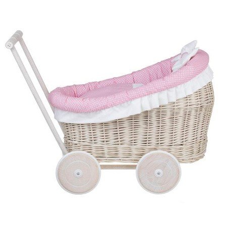 7. Side profile of whitewashed wicker doll pram with pink bedding, studio setting