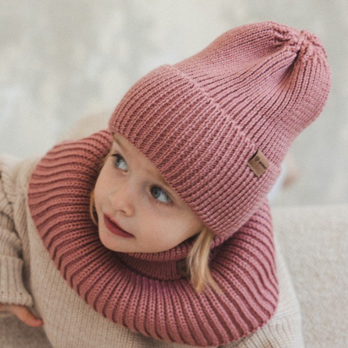 5. Close-up of child in blush merino wool hat and neck warmer on beige sofa