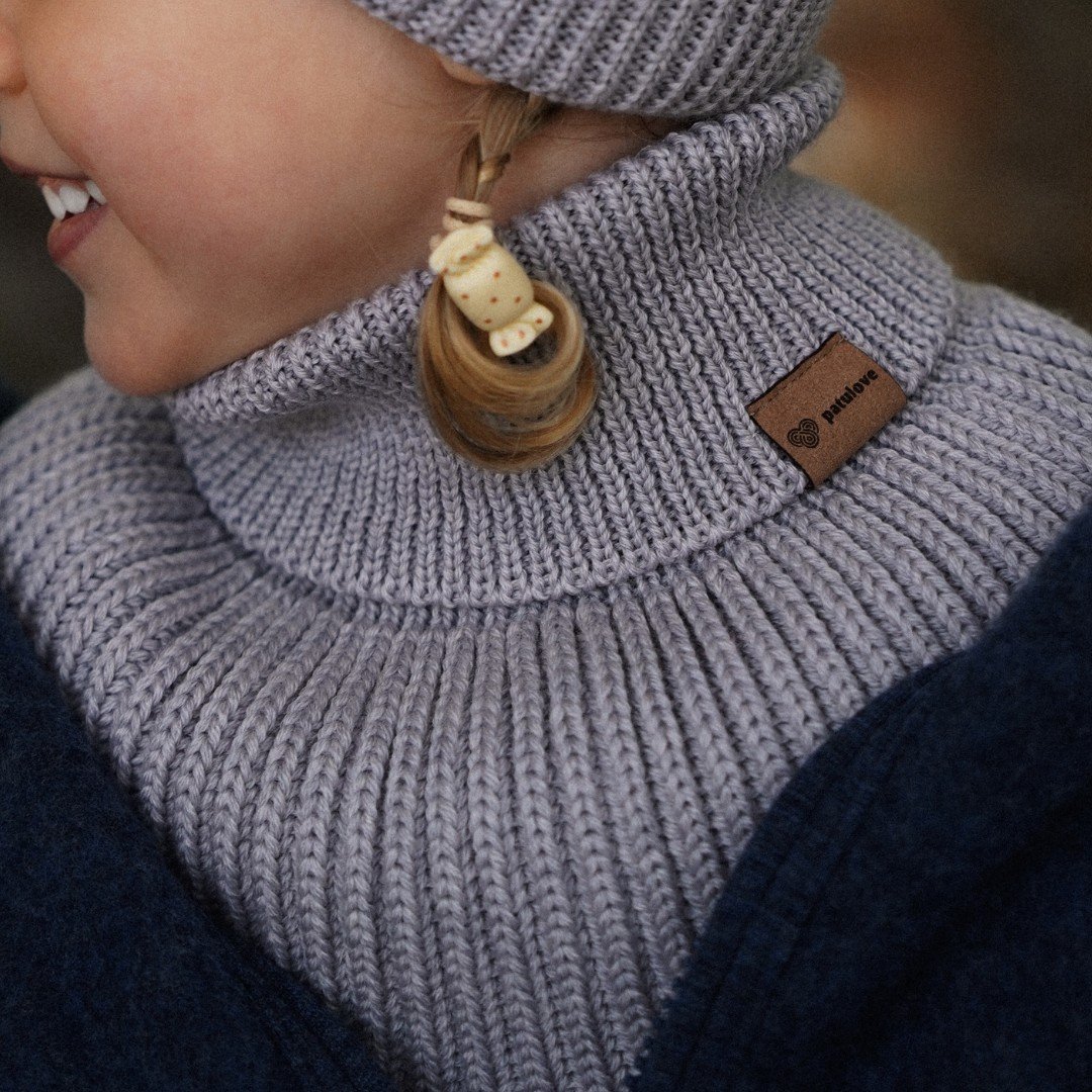 1. Child wearing grey merino wool tube scarf and hat by Patulove, smiling outdoors