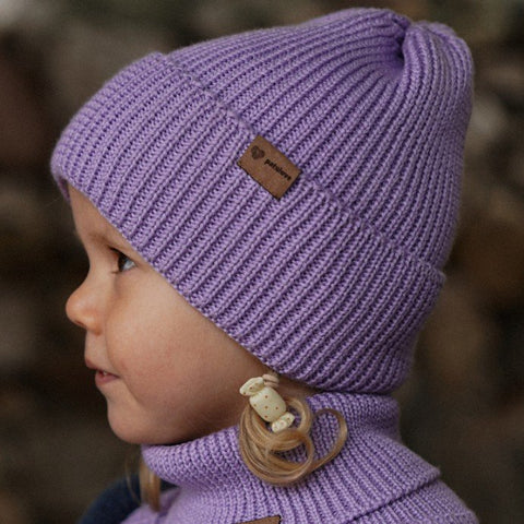 1. Child wearing lavender merino wool hat with fold-over cuff, side profile, outdoors