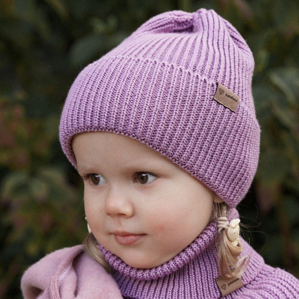 1. Child wearing lilac merino wool hat and matching scarf outdoors with greenery background