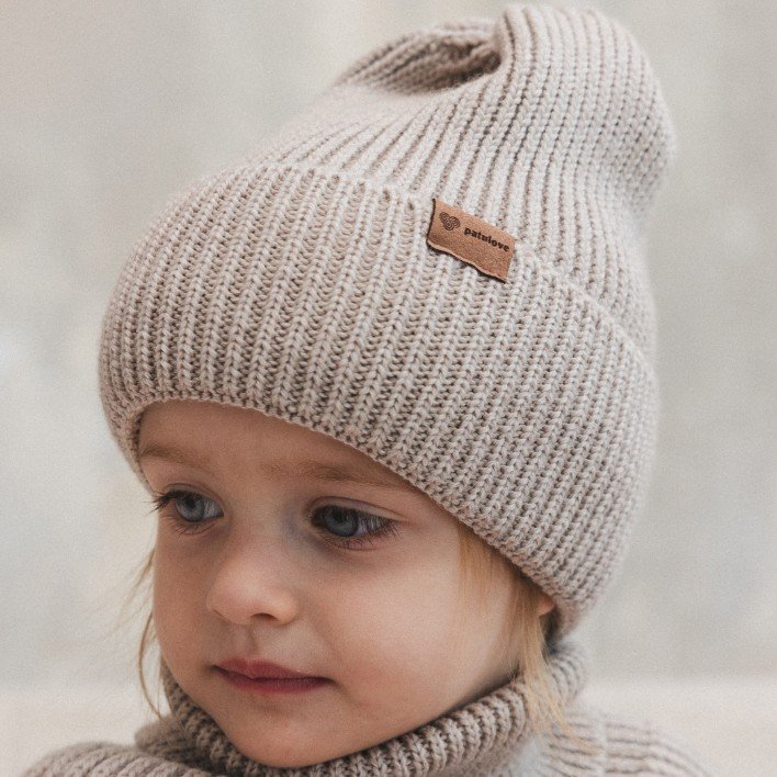 1. Child wearing Patulove oat-colored merino wool hat with fold-over cuff, indoors