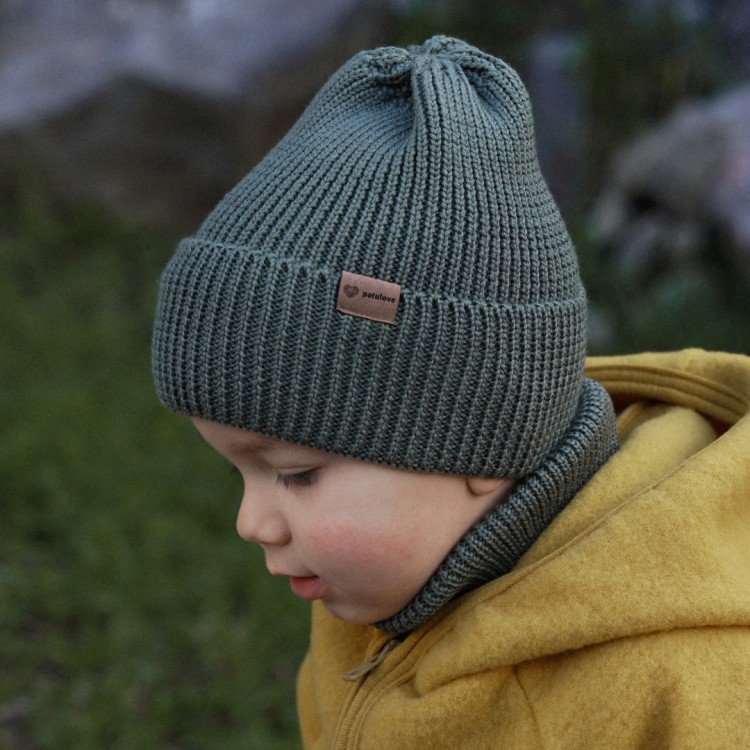 1. Child wearing olive merino wool hat by Patulove with yellow jacket in outdoor setting
