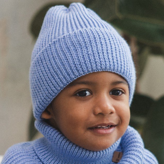 3. Close-up of child wearing sky blue merino wool hat and neck warmer, highlighting knit texture