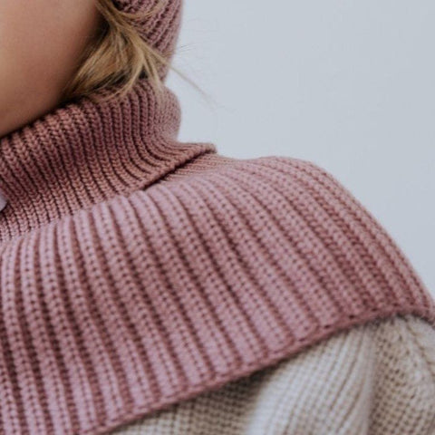 3. Close-up of blush merino wool tube scarf on child's neck and shoulders, showing ribbed texture and soft material