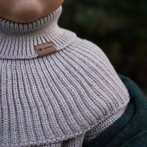 3. Close-up of Patulove oat merino wool tube scarf showing ribbed texture and logo tag