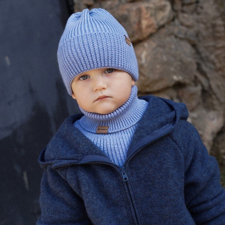 3. Child in sky blue merino wool tube scarf and hat by Patulove, wearing a navy jacket outdoors