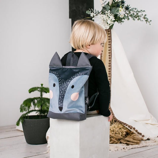 1. Child wearing Muni kids wolf backpack in lifestyle setting, showcasing playful design