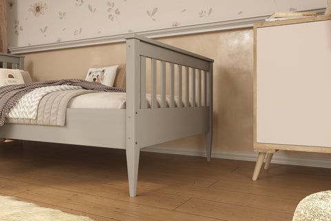 1. Gray wooden bed in a cozy bedroom setting with floral wallpaper and wooden flooring