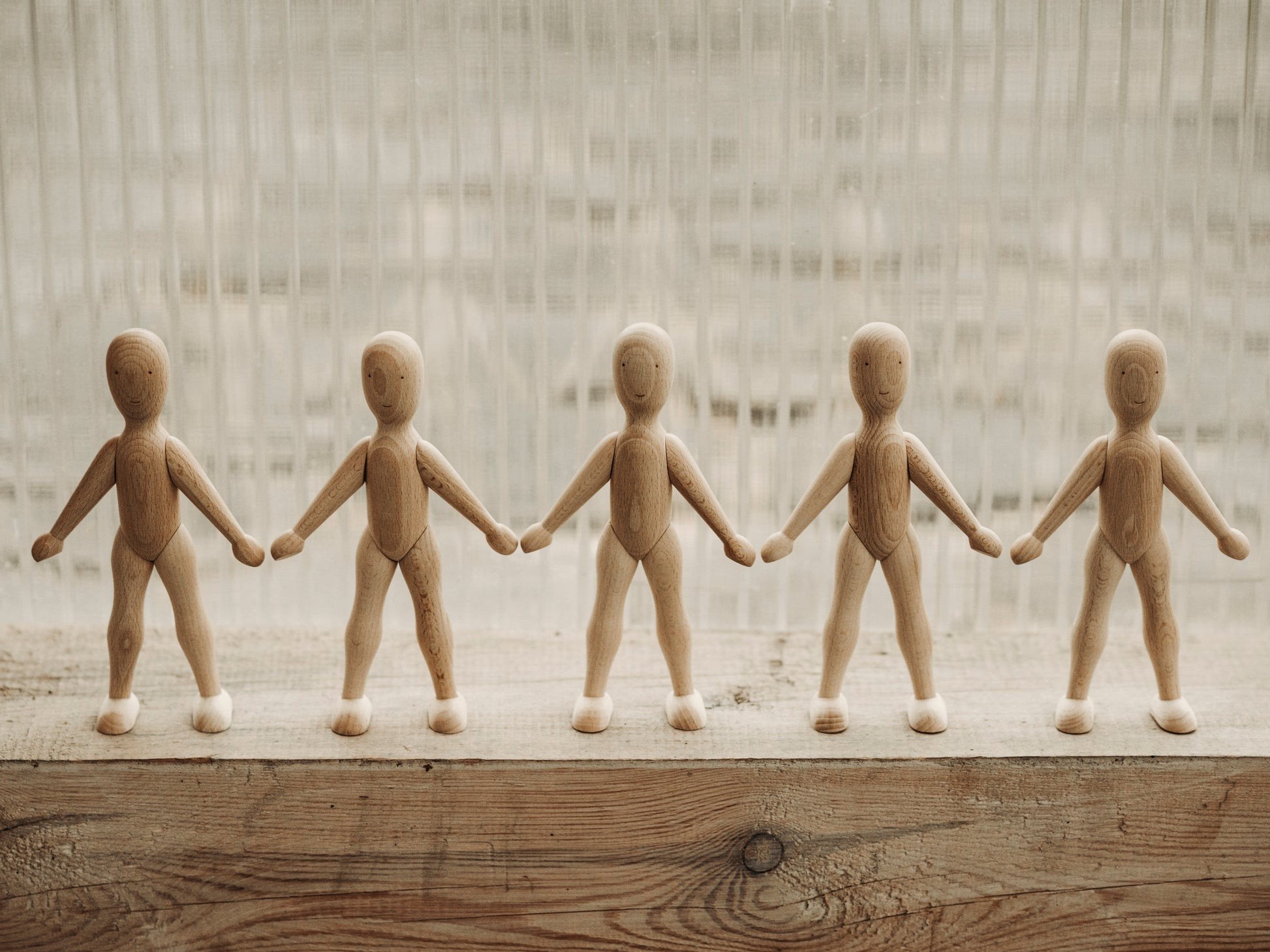 12. Five Wooden Story beech dolls standing in a row on wooden surface